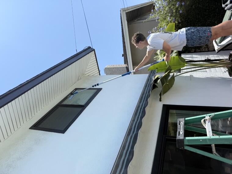Technician using an extension pole on a second-story window