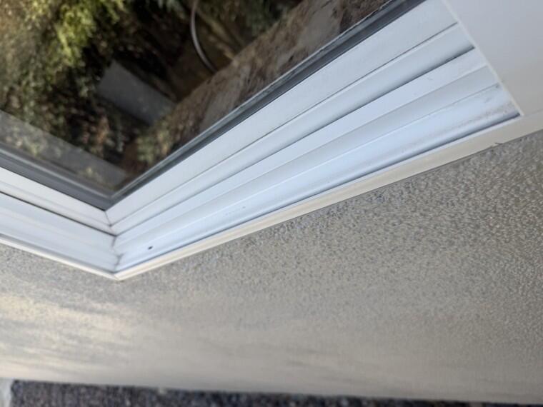 Technician wiping down a window frame and track