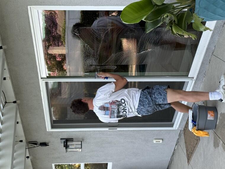 Sliding glass door being cleaned, suds mid-wipe