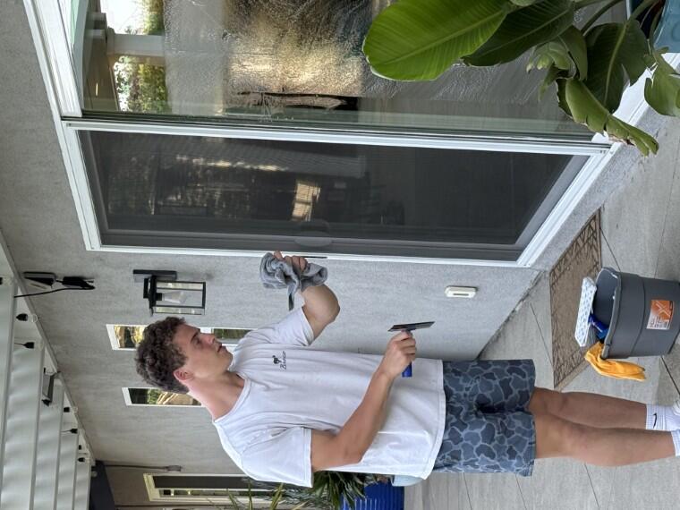 Close-up of a sliding door track and frame being wiped